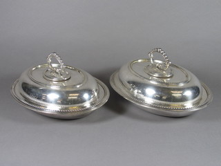A pair of oval silver plated entree dishes and covers with bead  work borders