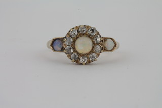 A lady's 18ct gold dress ring set an opal surrounded by diamonds and with 2 opals to the shoulders