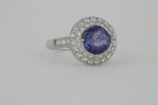 A lady's 18ct white gold dress ring set a circular cut sapphire surrounded by diamonds