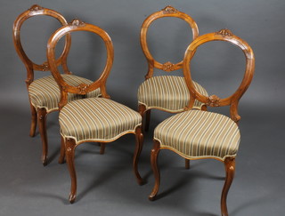 A set of 4 Victorian carved walnut balloon back dining chairs,  the seats of serpentine outline, raised on cabriole supports, one  with very slight worm,