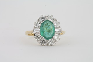 A lady's 18ct yellow gold dress ring set an oval cut emerald surrounded by diamonds approx 1.80/1.20ct
