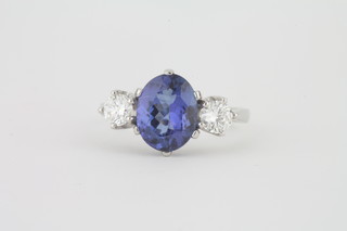A lady's 18ct white gold dress ring set an oval cut tanzanite  supported by 2 diamonds, approx 2.80/0.60ct