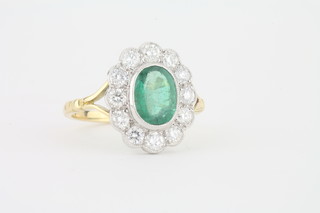 A lady's 18ct yellow gold dress ring set an oval emerald  surrounded by diamonds approx 1.35/0.80ct