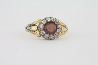 A gold cluster dress ring set red stones surrounded by diamonds