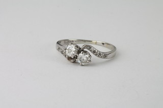 A lady's 18ct white gold cross-over dress ring set 2 diamonds  and with diamonds to the shoulders