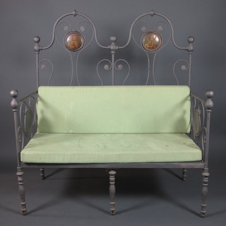 A 20th Century Continental wrought and tubular steel canape with transfer decorated roundels depicting religious scenes, fitted  loose cushions, raised on casters