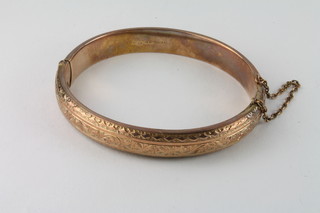A 9ct engraved hollow gold bangle