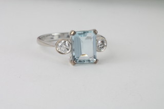 An 18ct white gold dress ring set a rectangular cut aquamarine supported by 2 diamonds