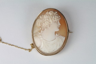 A shell carved cameo brooch contained in a 9ct gold mount and a gold Royal Naval sweetheart brooch