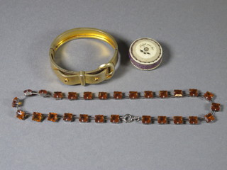 A gilt metal bracelet and a bracelet set square cut amber coloured  stones and a carved ivory pin cushion