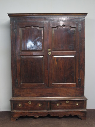 An early 18th Century oak press cupboard with moulded cornice  above a pair of fielded panelled cupboard doors with 2 short  drawers below, raised on a shaped plinth base, altered, 70.5"h x  51.5"w 20"d