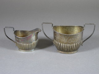An oval silver twin handled sugar bowl together with a matching cream jug with demi-reeded decoration, Birmingham 1928,  5ozs