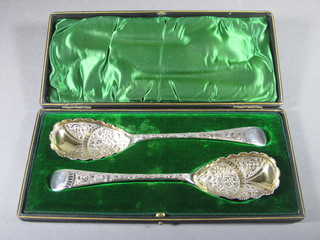 A pair of silver plated berry spoons, cased