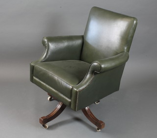 An early 20th Century green leather swivel desk chair, raised on quadripartite base and casters