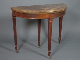 An Edwardian mahogany demi-lune card table, the hinged top enclosing a baize lined interior, raised on square tapered fluted  legs with spade feet and casters 30"h x 26"w x 18"d
