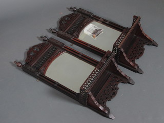 A pair of late Victorian walnut wall brackets in the Sheraton  taste, having scroll carved cornices above a mirrored plate,   flanked by column supports 27"h x 12"w x 6.5"d