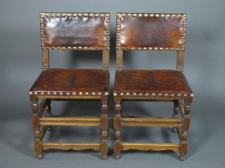 A set of 6 mid 17th Century style oak dining chairs, having brass studded leather backs and seats, raised on turned under frames  with peg feet
