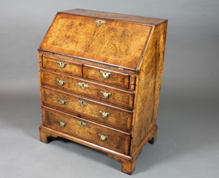 An early 18th Century and later walnut bureau, crossbanded, the  fall enclosing a fitted interior with dark green leather, gilt tooled  skiver above 2 short and 3 graduated long drawers, raised on  shaped bracket feet 39"h x 30.5"w x 20"d