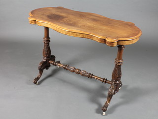 A mid Victorian walnut centre table of serpentine form, raised on  column supports, scroll feet united by a turned stretcher 28"h x  41.5"w x 22"d