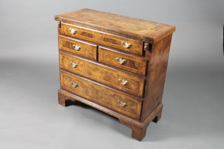 A George I style burr walnut bachelor's chest, feather and crossbanded, the hinged folding top supported by lopers above an  arrangement of 5 drawers, raised on shaped bracket feet 28.5"h x  30"w  ILLUSTRATED