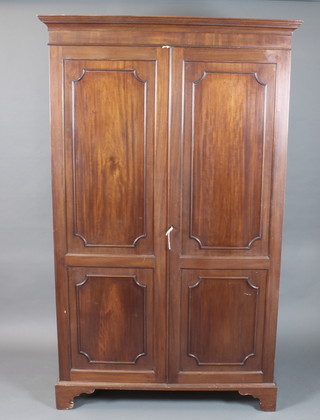 A 1920's mahogany wardrobe with moulded cornice above a pair  of field panelled cupboard doors enclosing a hanging rail and  linen drawer, raised on shaped bracket feet 74"h x 45"w x 23"d