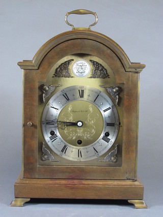 Elliott London, a 17th Century style walnut bracket clock having  a broken arch brass dial, silvered Arabic and Roman chapter  ring, flanked by mask spandrels, the quarter repeating 8 day lever  movement with Westminster and Whittington chimes on 8 gongs,  movement no. 27344, retailed by Mappin & Webb Ltd. 14.5" x  10"h x 6.5"d
