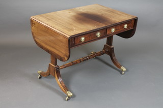 A Regency style mahogany sofa table, boxwood line inlaid, fitted  2 short drawers raised on splayed legs united by a turned  stretcher, brass claw caps and casters 26.5"h x 55.5"w x 23.5"