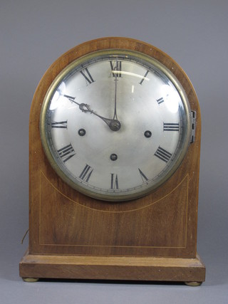 An Edwardian mahogany bracket clock, having silvered Roman  dial, set 3 train quarter repeating 8 day movement with  Westminster chime on gongs, the arched top case Oxford line  inlaid, raised on a plinth base, 14"h x 11"w x 6.5"d