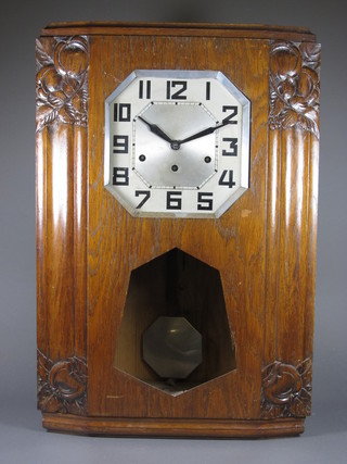 An Art Deco oak cased wall clock having octagonal silvered Arabic dial, set 8 day movement chiming gongs, the case with  foliate relief carved decoration 25"h x 17"w x 6"d