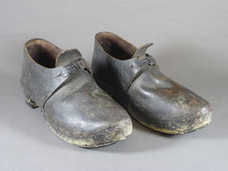 A pair of wooden and leather pitt clogs