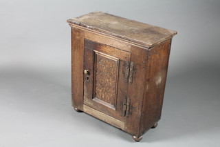 A 17th Century and later food hutch with moulded top above a  scroll carved panelled door, raised on bun feet, altered 28"h x  26"w x 12"d