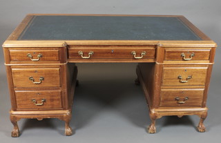 A mahogany inverted breakfront pedestal desk with inset blue  writing skiver, above 1 long and 6 short drawers, raised on  cabriole supports 60"w x 36"d x 29"h