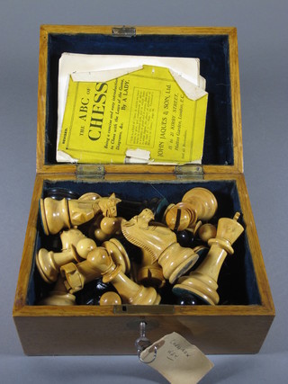 A 19th Century carved wooden chess set contained in a honey oak box with hinged lid