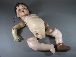 A German porcelain headed doll with open mouth, open and shutting eyes and articulated body, the head incised German 14
