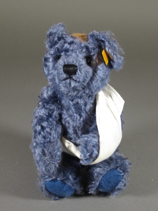 A blue coloured Steiff bear with sling and bandage to head 9"