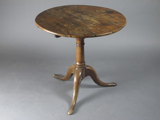 An 18th Century circular elm tilt top tea table with bird cage  support, raised on a gun barrel and tripod base 28"w x 28"h