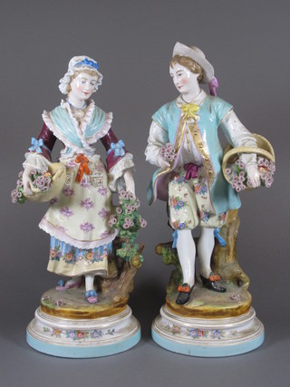 A pair of 19th Century Continental porcelain figures of a  standing lady and gentleman with baskets of flowers 14.5"  ILLUSTRATED