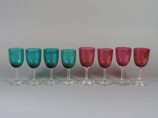 4 cranberry glass wine glasses with clear glass stems and 4 green  glass wine glasses with clear glass stems