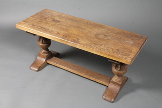 An oak coffee table in the 17th Century taste, raised on carved  cup and cover supports and block feet 18"h x 39.5"w x 16"d