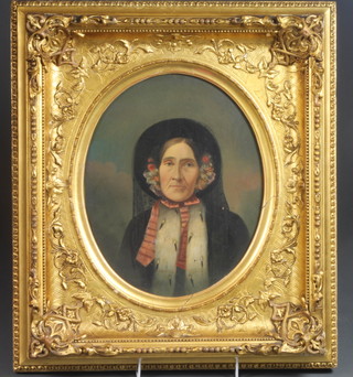 A 19th Century Continental School, oil on card, head and shoulder portrait of a lady, the sitter wearing a black veiled floral  bonnet and crimson scarf, feined to oval 12.5"h x 10.25w, within  a carved giltwood frame with foliate spandrels on blind lattice  ground, frame 20.5"h x 18"w