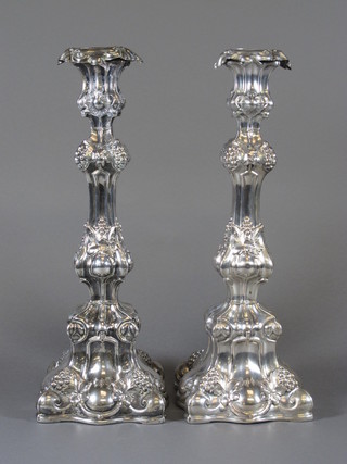 A pair of Continental embossed white metal candlesticks with detachable sconces 12"