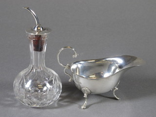 A silver sauce boat with wavy border and C scroll handle  Birmingham 1938 1 ozs, together with a cut glass bitters jar with  silver cover