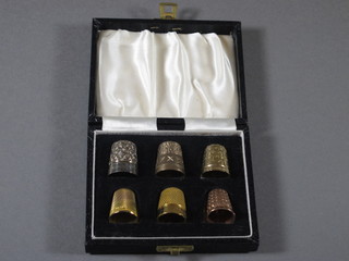4 gold thimbles, a gold plated thimble and a silver thimble, cased