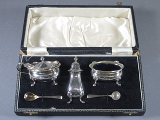 A 3 piece silver condiment set comprising salt, mustard and pepper pot with blue glass liners, liners f, together with 2  condiment spoons, Birmingham 1951, cased