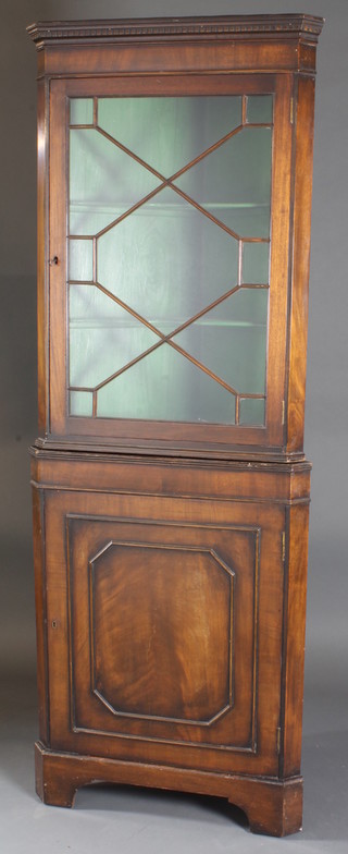 A late George III mahogany standing corner cabinet, the upper section with moulded dentil cornice, the shelved interior  enclosed by an astragal glazed panelled door, with panelled  doors below, raised on bracket feet 27"w x 15"d x 75"h