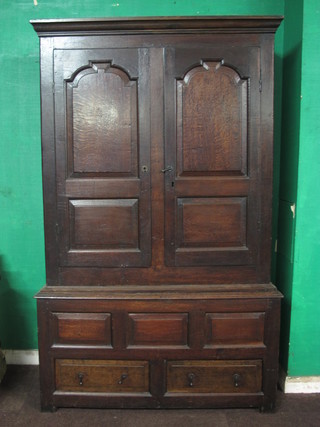 An early 18th Century oak press cupboard, having plain moulded cornice above a pair of fielded panelled doors with 2 short  drawers below, raised on end stiles, modified, 73"h x 46"w