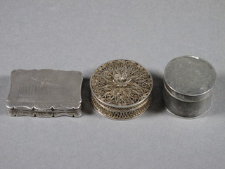 A Victorian rectangular engraved silver vinaigrette, grill missing,  the lid decorated a building London 1852, a Victorian cylindrical  jar and cover London 1845 and a filigree jar and cover