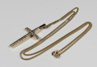 A 9ct gold cross set numerous diamonds hung on a fine gold  chain