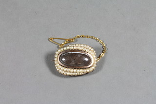 A Victorian gilt metal mourning brooch set a woven hair panel surrounded by demi-pearls, the reverse engraved Reverend  Franklin