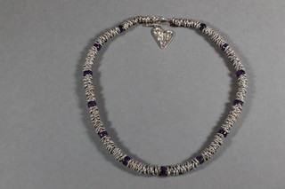 A silver necklet interspaced sections of amethyst